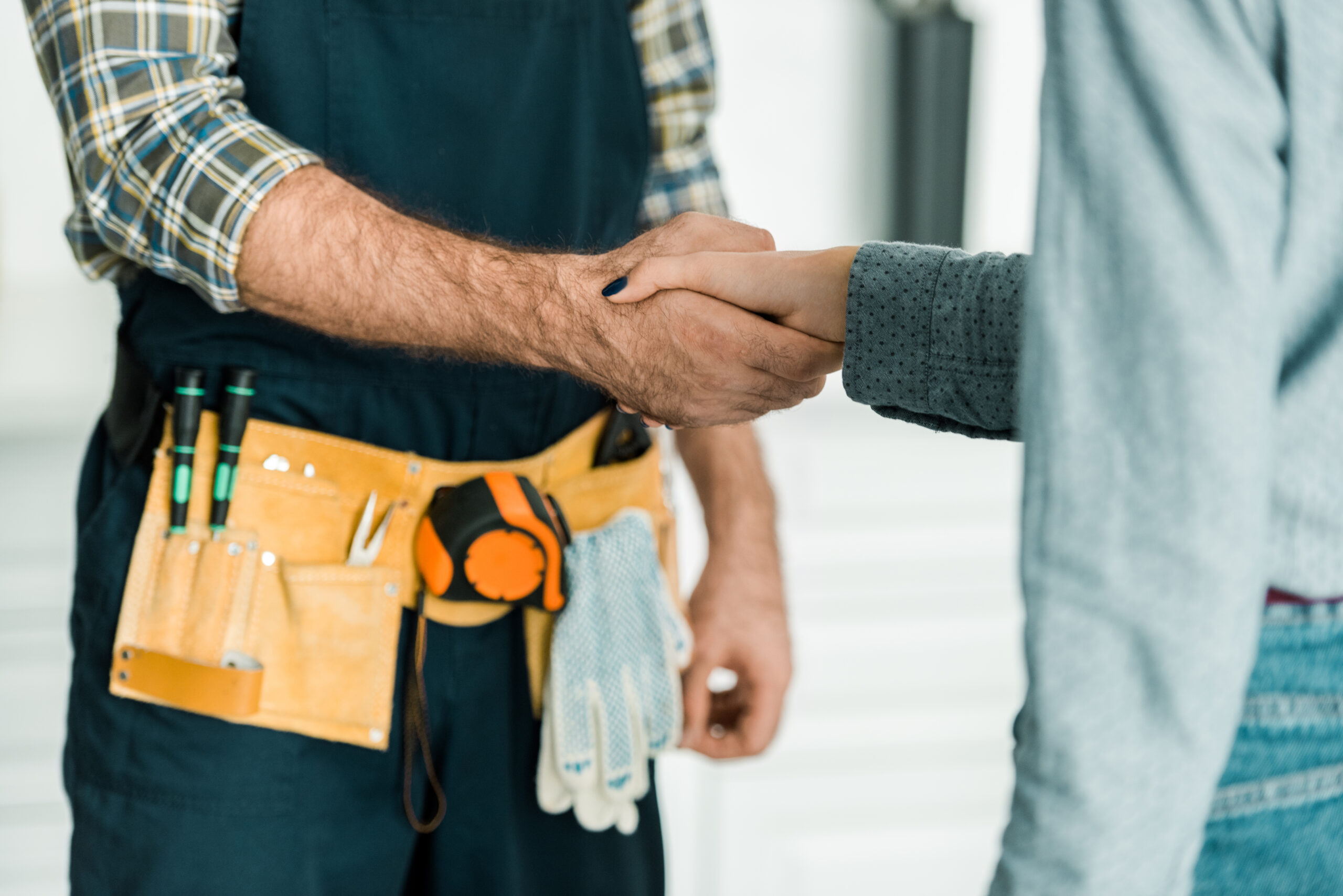 Cropped,image,of,plumber,and,customer,shaking,hands,in,kitchen